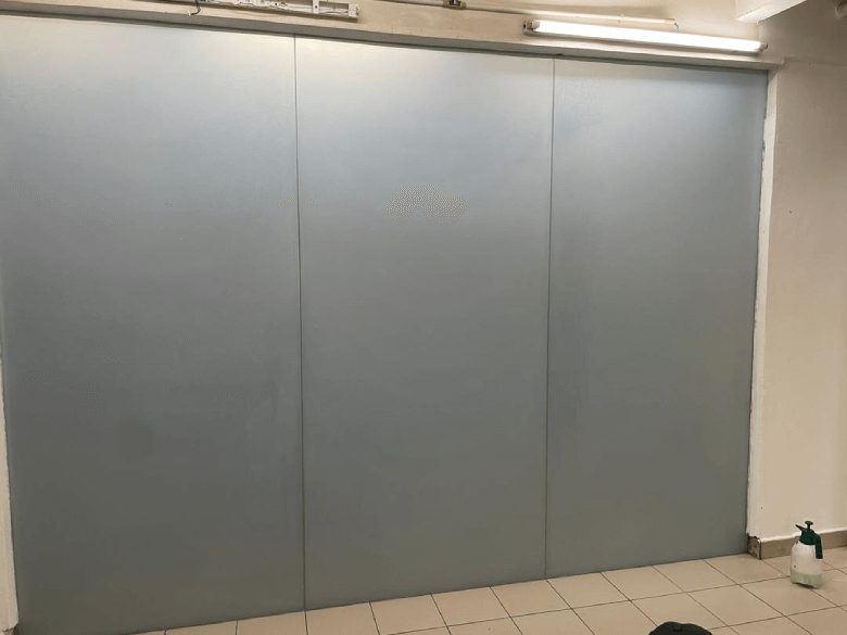 (FD) 136 - Frosted Window Film Kuala Lumpur Three large gray metal doors in a tiled hallway, with a green bottle on the floor to the right under fluorescent lights.
